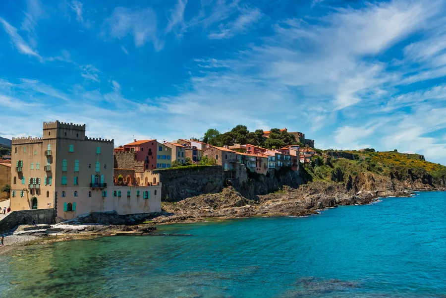 Village côtier coloré au bord d’une mer turquoise.