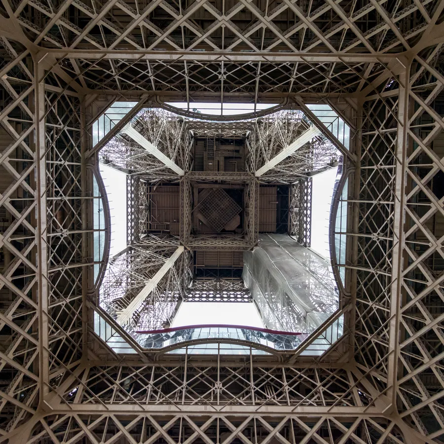 Vue verticale sous la structure métallique de la tour Eiffel.