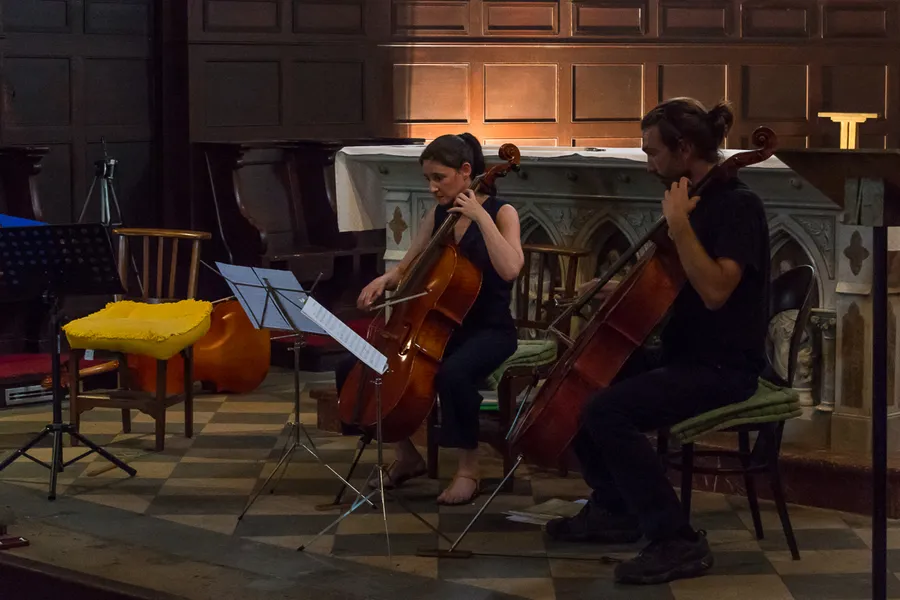 Deux violoncellistes jouant dans une église.