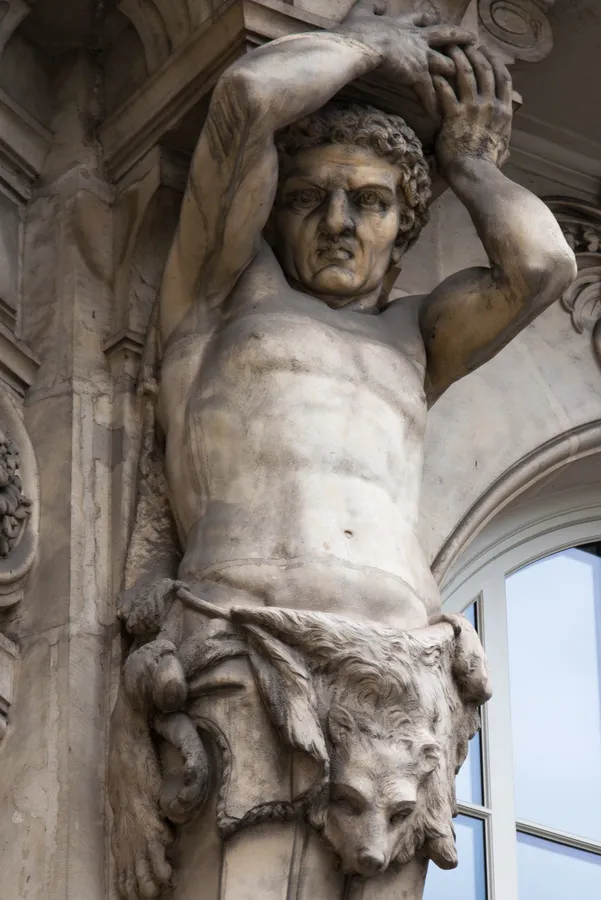 Sculpture de pierre intégrée à une façade monumentale.