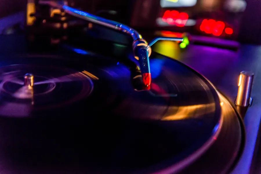 Platine vinyle éclairée par des lumières colorées.