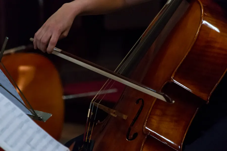 Gros plan sur un archet et un violoncelle pendant une interprétation.