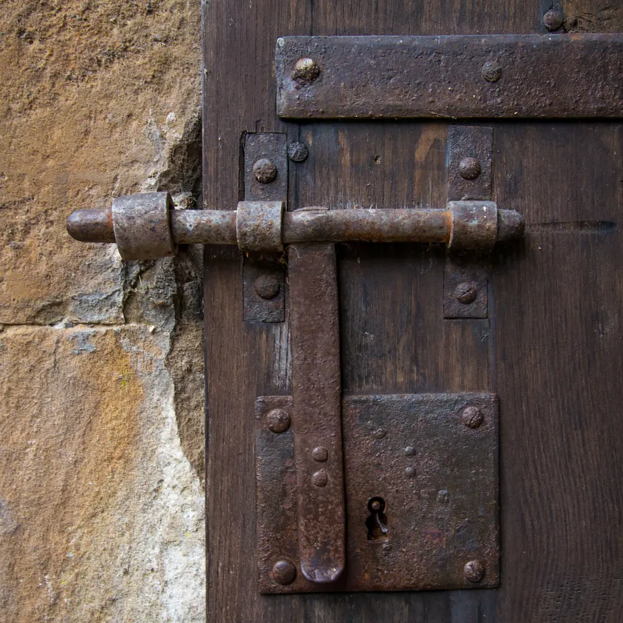 Ancien verrou métallique sur une porte en bois.